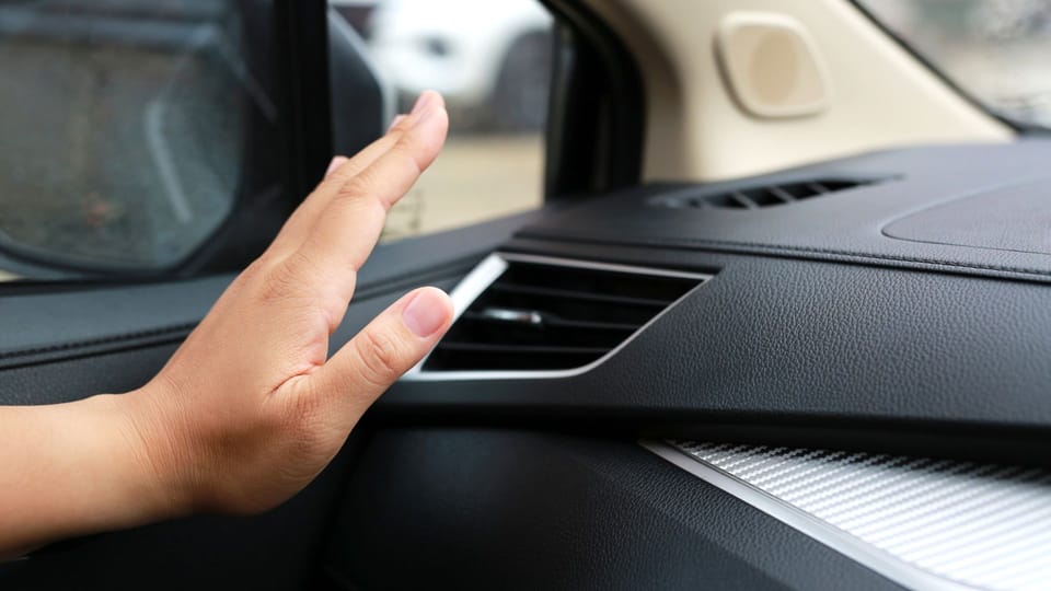 a person's hand on the dashboard of a car.|a man holding a wrench and a wrench on the ground.|a close up of a metal object with a hole in it.|a man holding two screws in his hand.