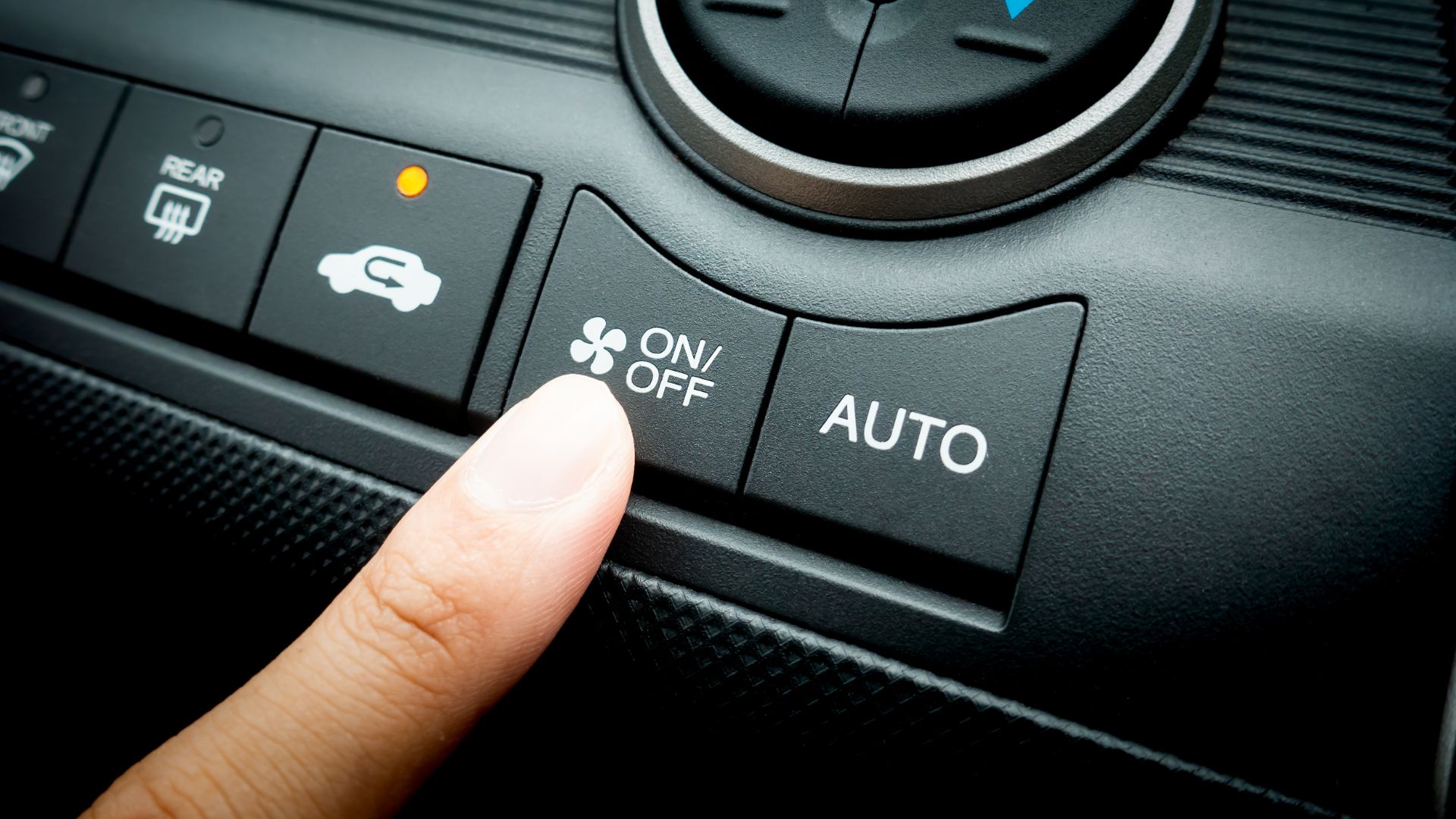 a person pressing a button on a car radio.|a close up of a metal gear on a vehicle.