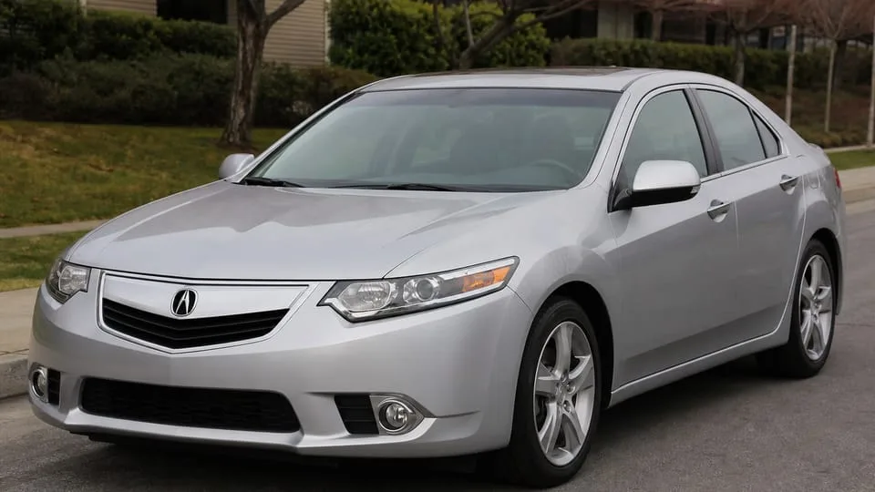 A silver Acura TSX sedan parked on a street.
