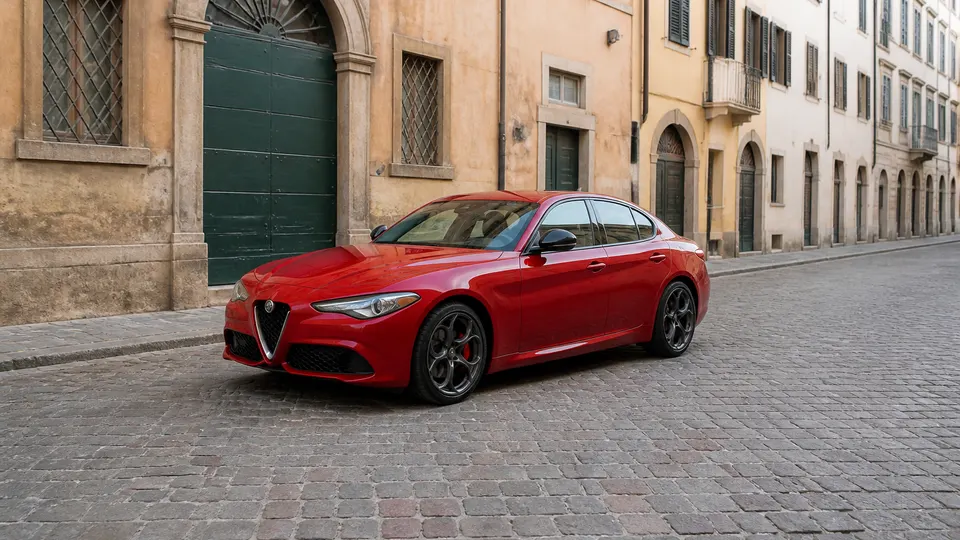 An Alfa Romeo Giulia sedan, three-quarter front view, parked on a European street.