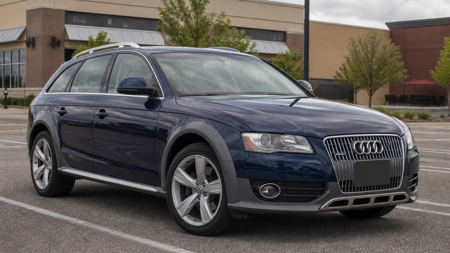 A dark blue 2013 Audi Allroad parked in a shopping center lot.