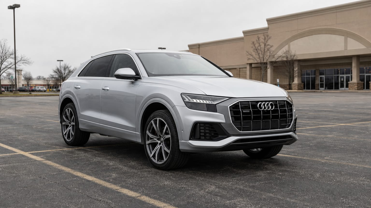A silver 2019 Audi Q8 parked in a shopping center lot.