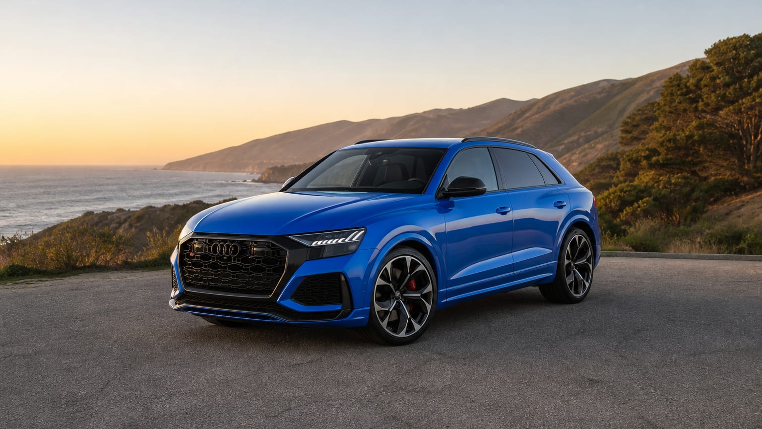 A late-model 2022–2023 Audi RS Q8 on a coastal cliff road.