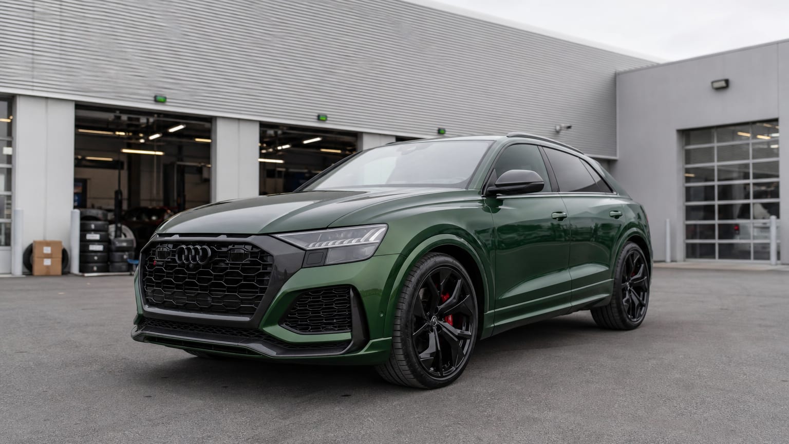 A dark green 2020–2021 Audi RS Q8 in a dealership service bay lot.