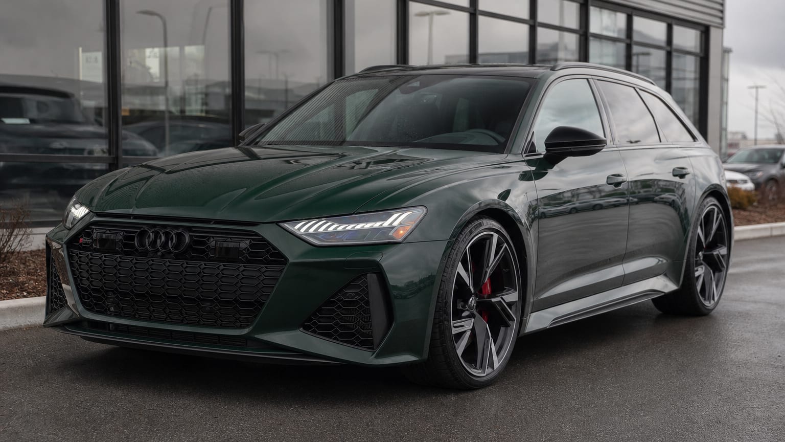 A dark green 2021 Audi RS6 Avant parked in a dealership lot.