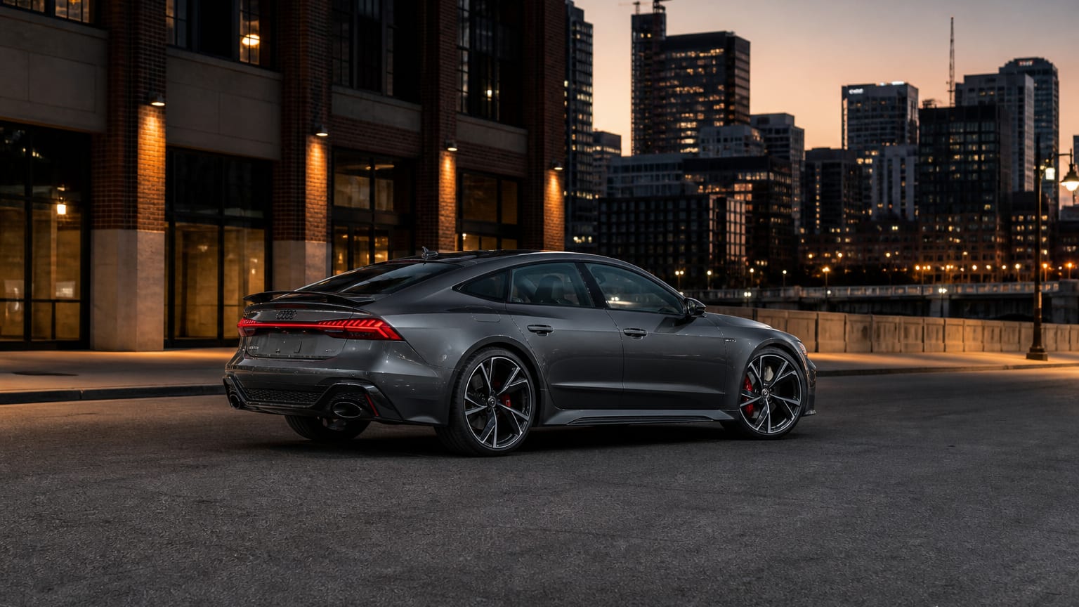 A Daytona Gray Audi RS7 Sportback parked on an empty urban street at dusk.