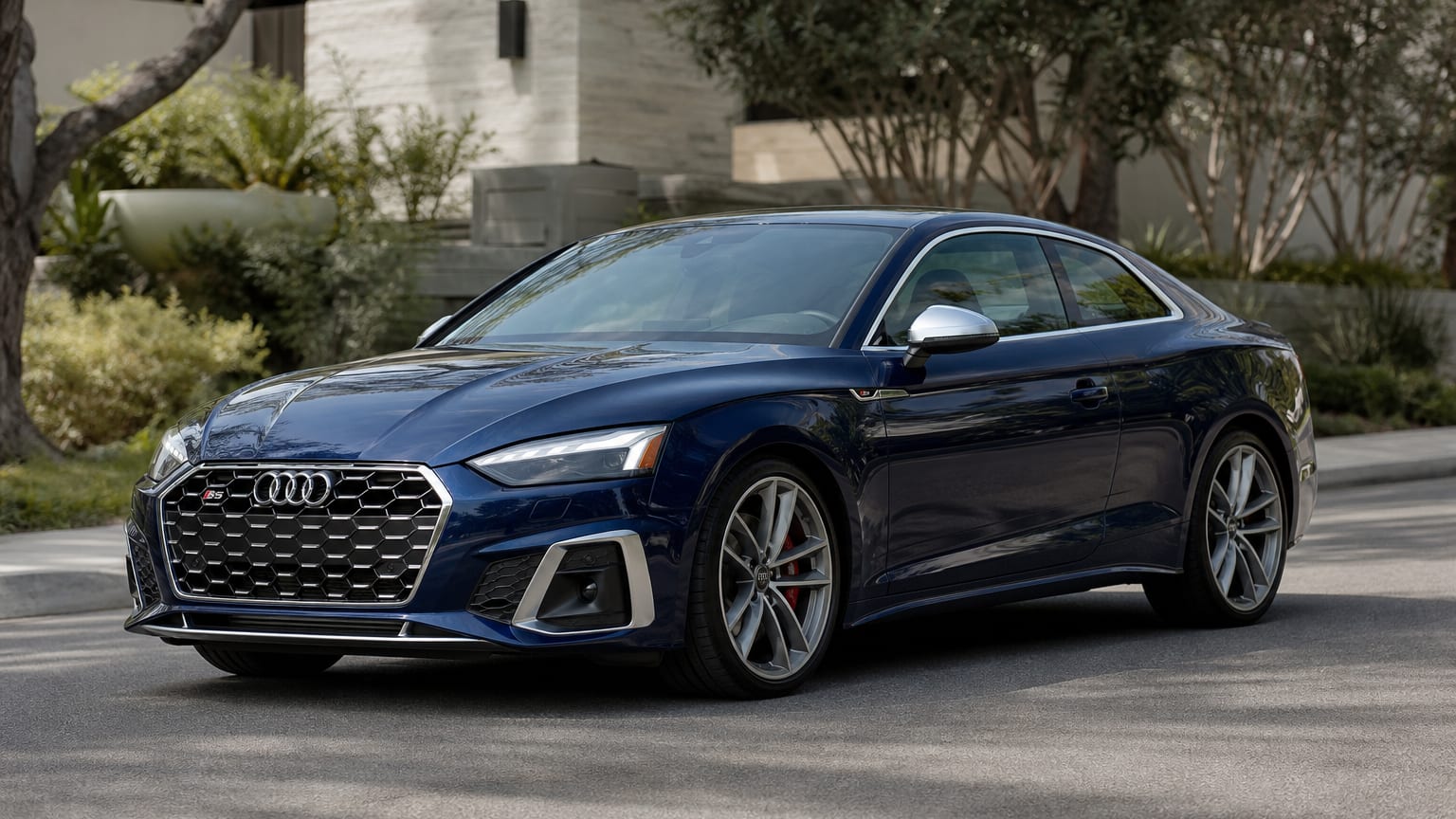 A late-model 2021–2023 Audi S5 on a quiet upscale street.