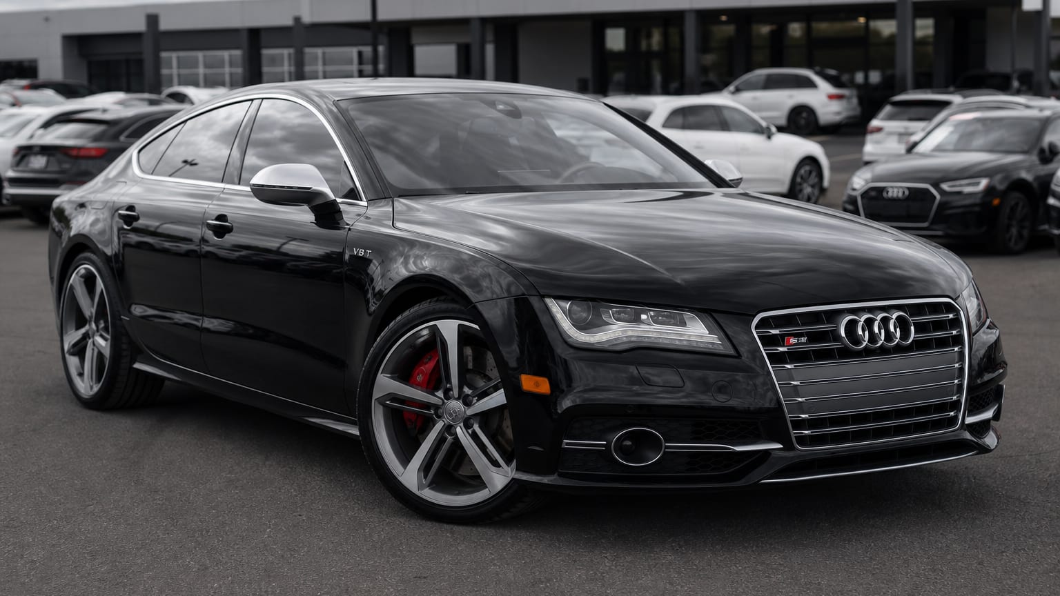 A black 2013–2016 Audi S7 parked in a dealership lot.