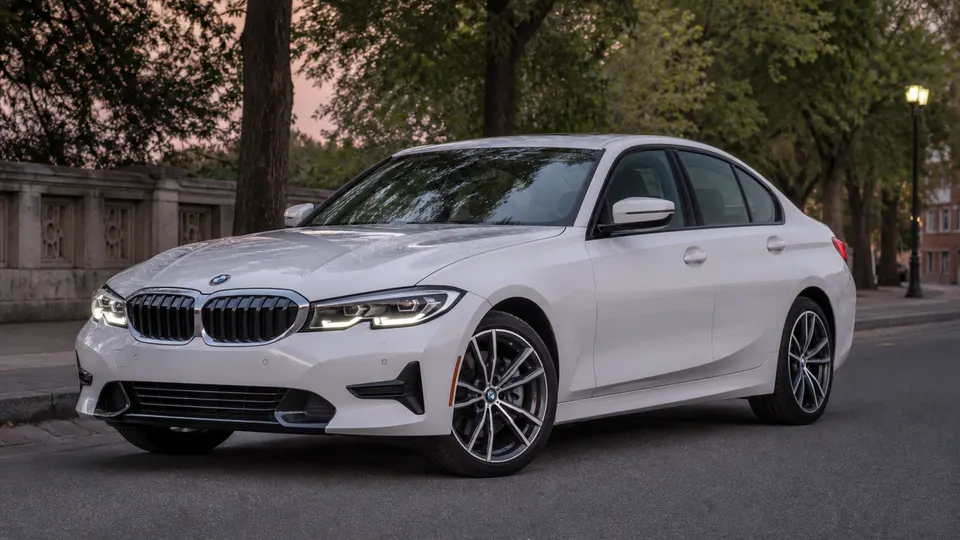 A silver BMW 3 Series sedan, three-quarter front view, parked on a city street.