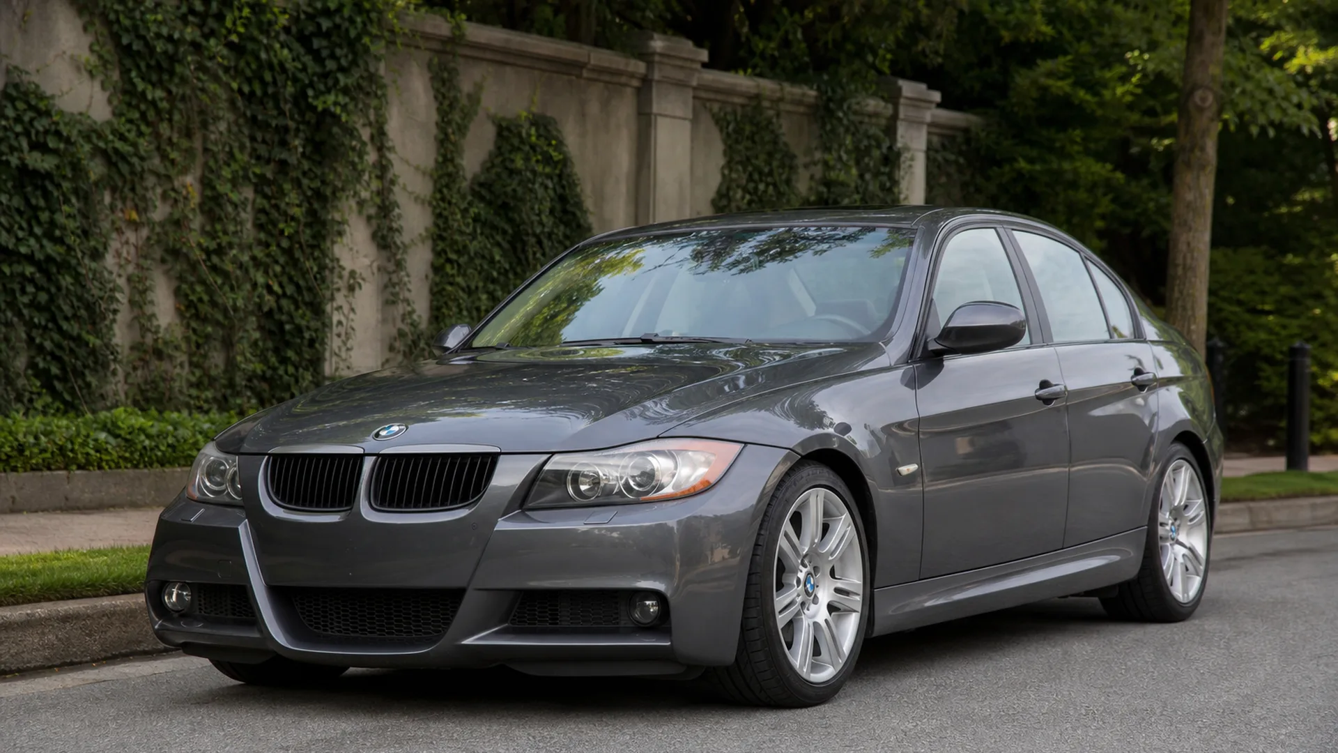 A grey BMW 335i sedan parked on a street.