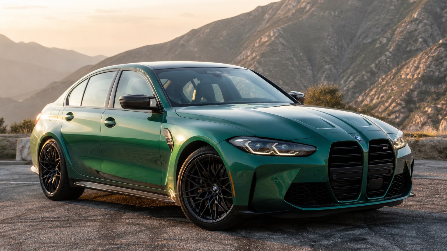 A modern Isle of Man Green BMW M3 sedan on a mountain road.