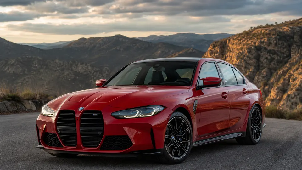 A red BMW M3 coupe, three-quarter front view, parked on an empty street.