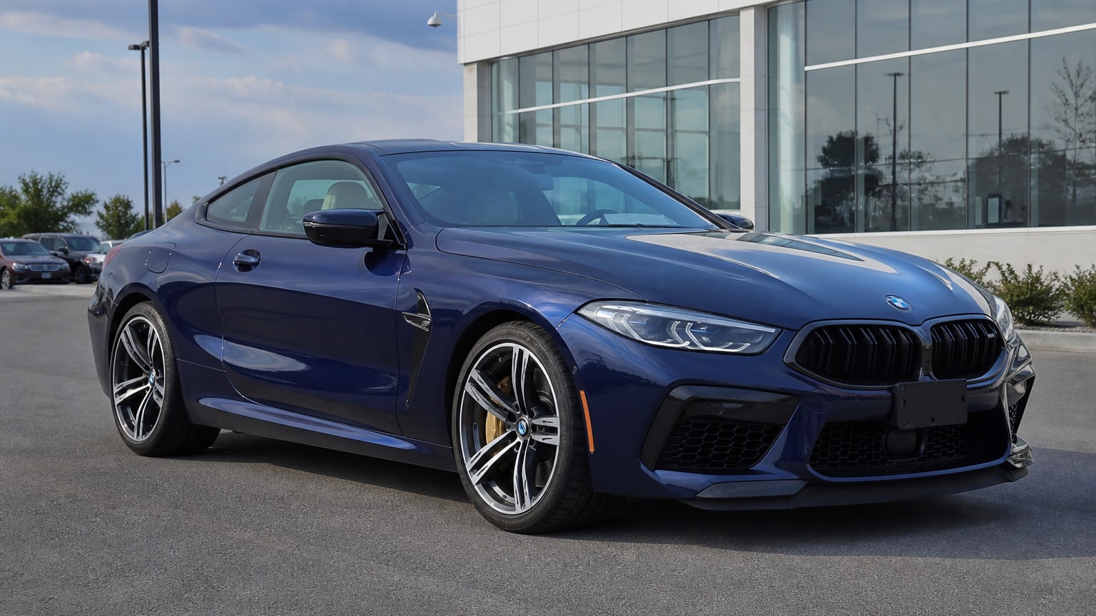 A higher-risk BMW M8 model year parked in a dealership lot.