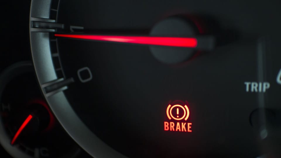 a close up of a car's brake light.|a hand is pressing a button on a car.