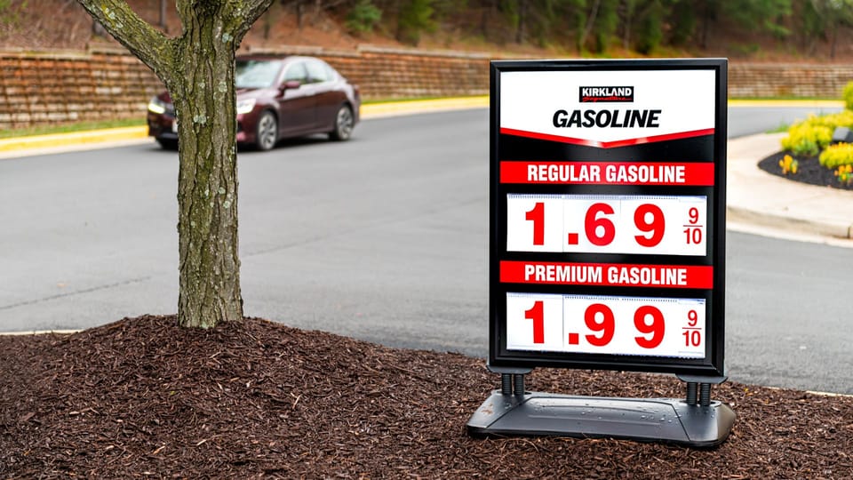 a gas station sign on the side of the road.|a gas pump filled with lots of different types of gas.|a row of gas pumps with gas prices on them.