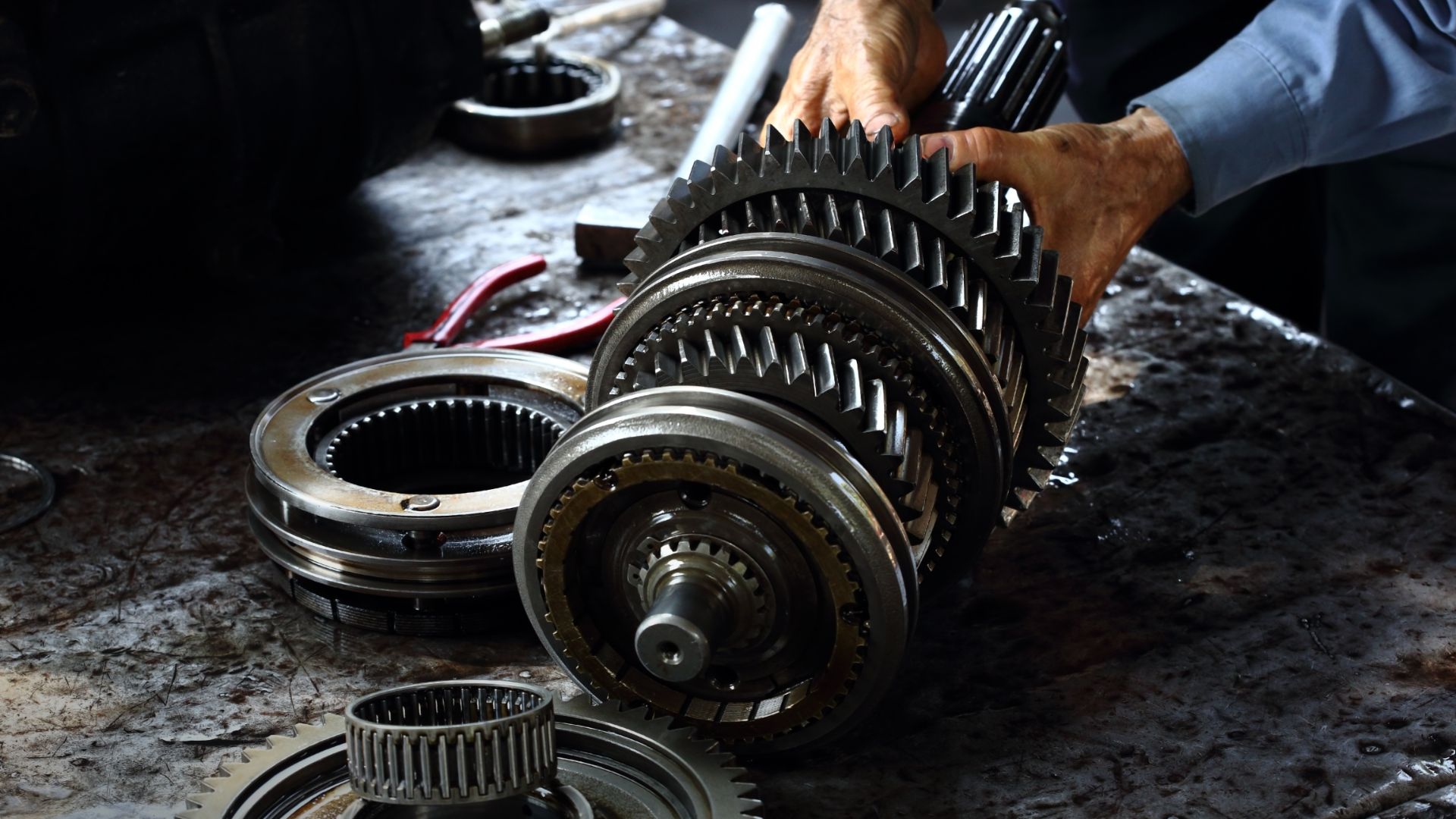 a close up of a person working on a machine.|a man is working on a car engine.|a close up of a bunch of metal objects.