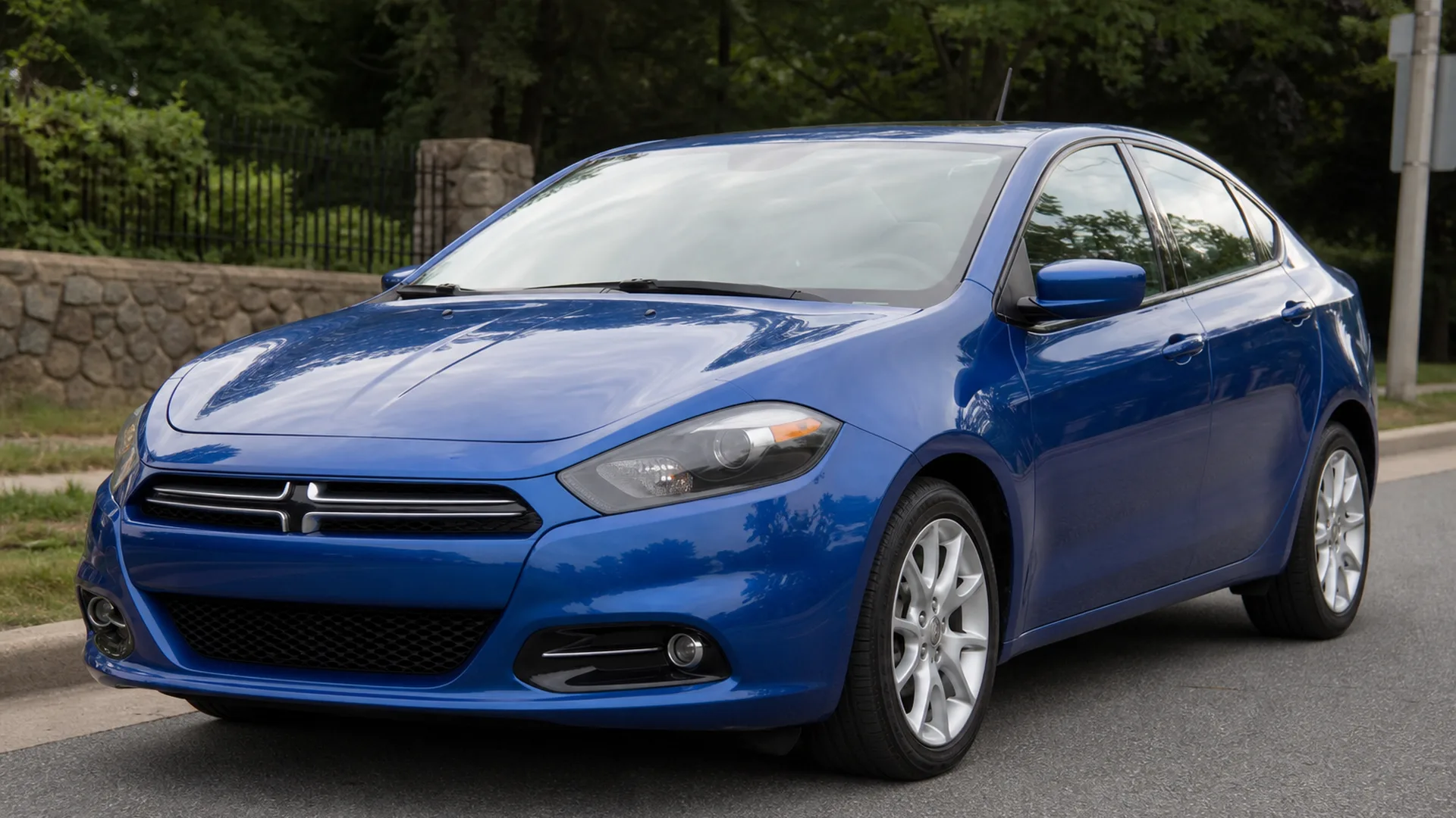A blue Dodge Dart sedan parked on a street.
