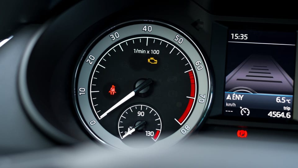 a close up of a speedometer on a car.|a man is working on a car engine.