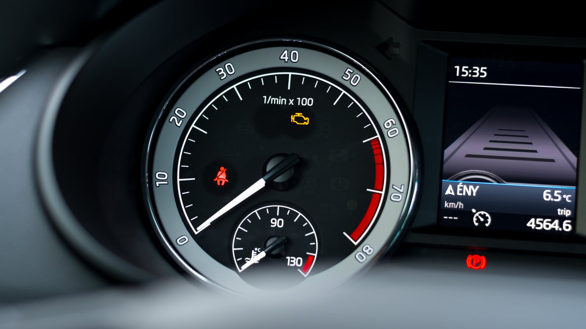 a close up of a speedometer on a car.|a man is working on a car engine.