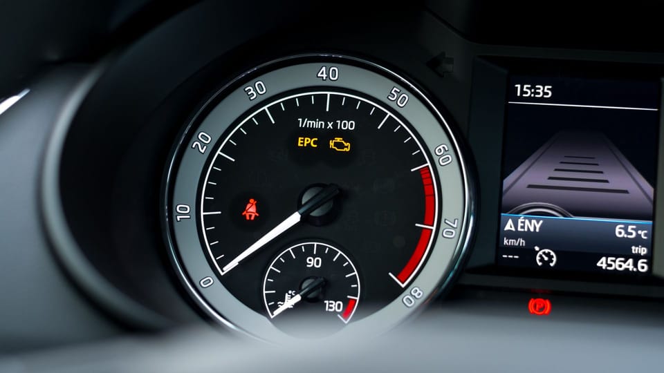 a close up of a speedometer in a vehicle.|a black car parked in a parking lot.|a man wearing gloves and holding a wrench.