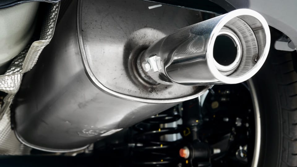 a close up of a car's exhaust pipe.|a close up of a motorcycle exhaust system.