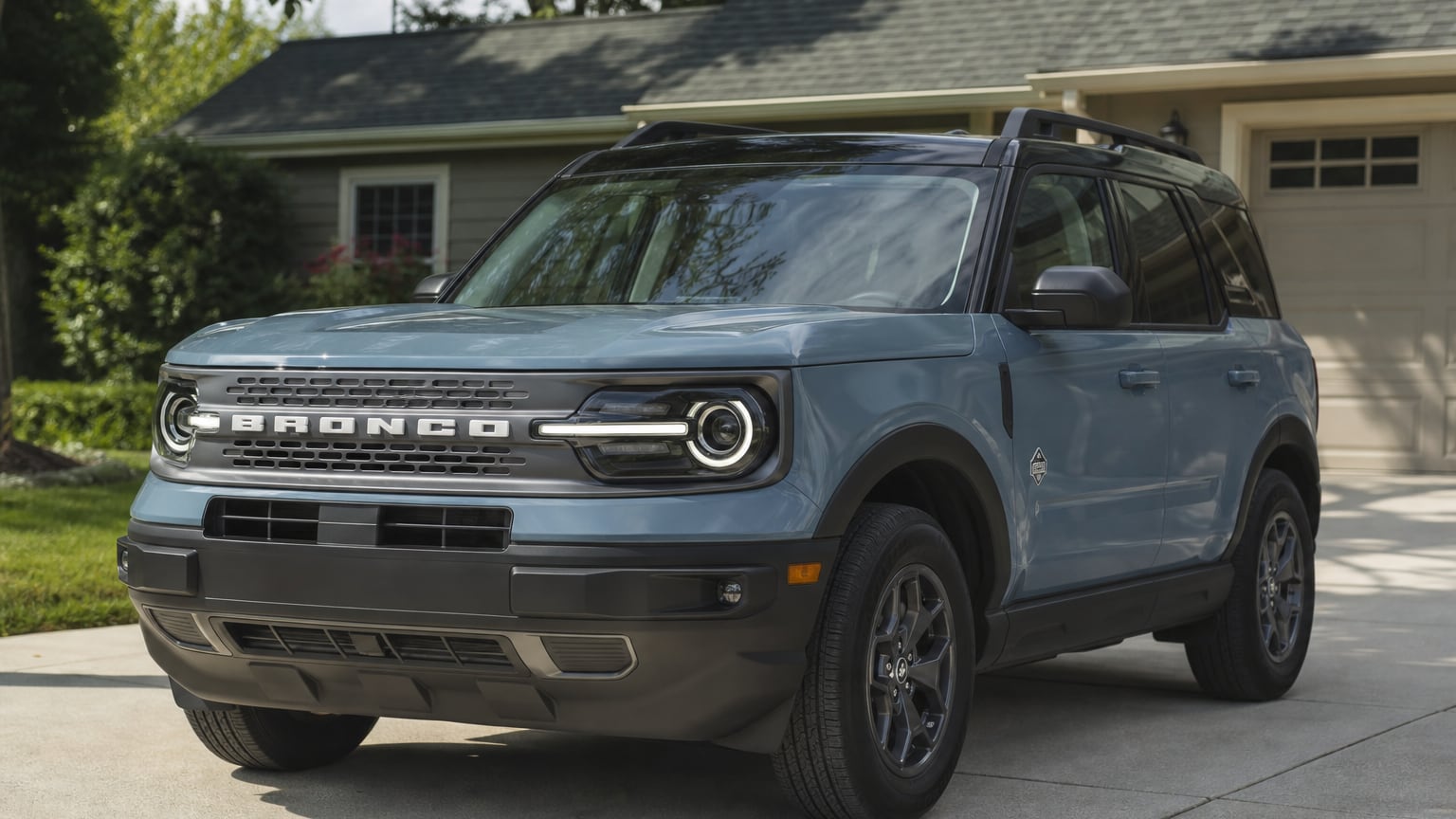 A blue 2021 Ford Bronco Sport compact SUV parked in a suburban driveway.