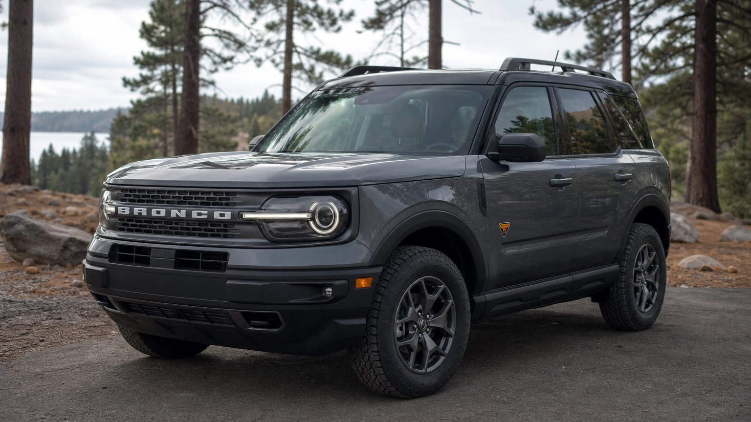 A gunmetal gray 2023 Ford Bronco Sport compact SUV parked at a trailhead lot.