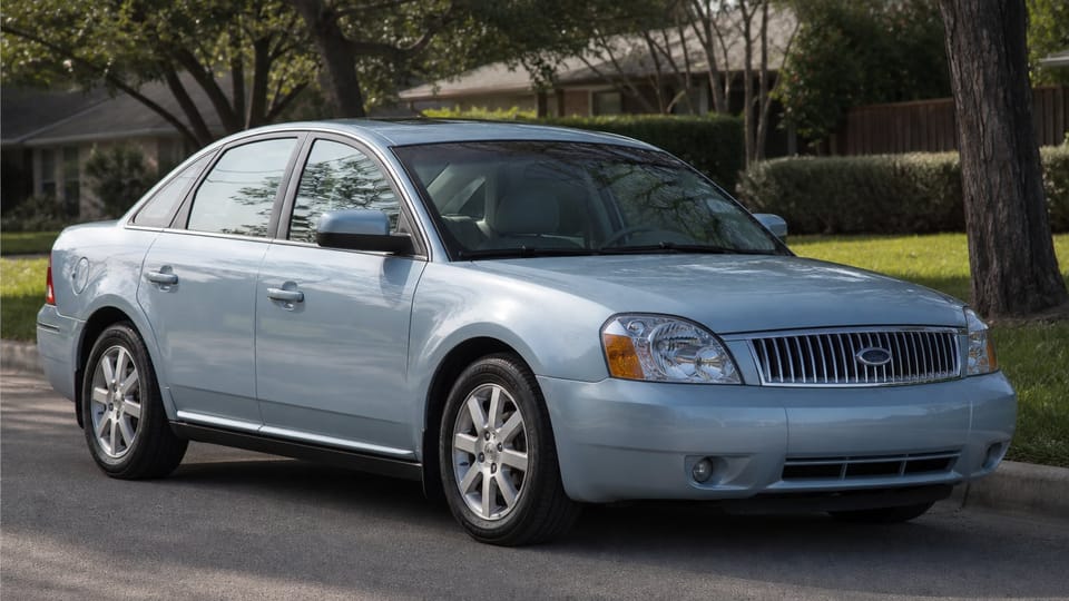 A silver mid-2000s Ford Five Hundred full-size sedan parked on a suburban street.