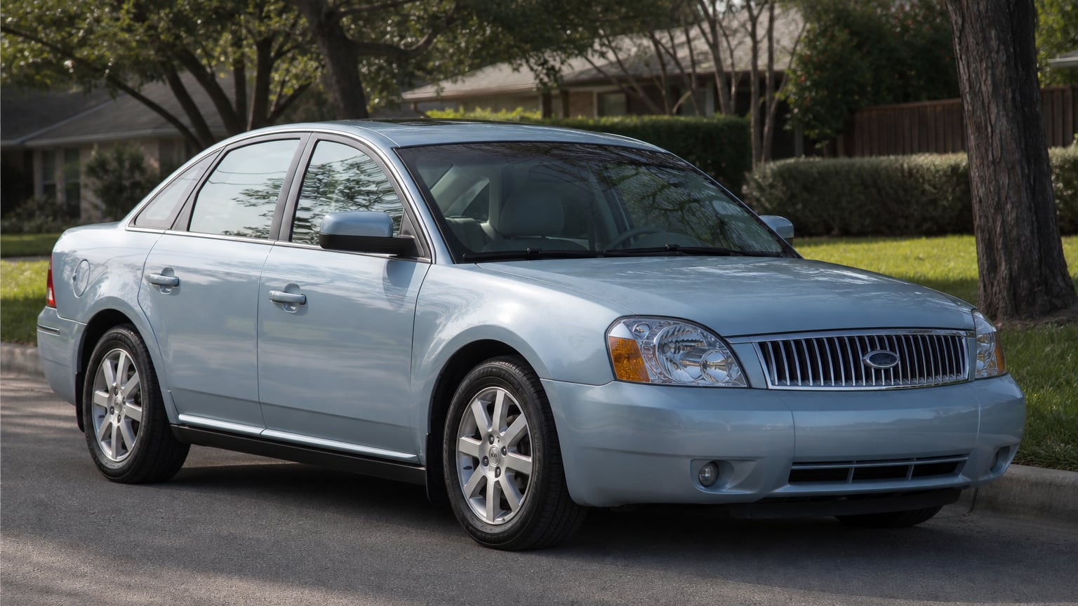 A silver mid-2000s Ford Five Hundred full-size sedan parked on a suburban street.