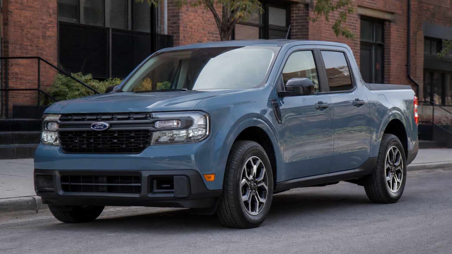 A blue 2024 Ford Maverick compact pickup truck parked on a city street.