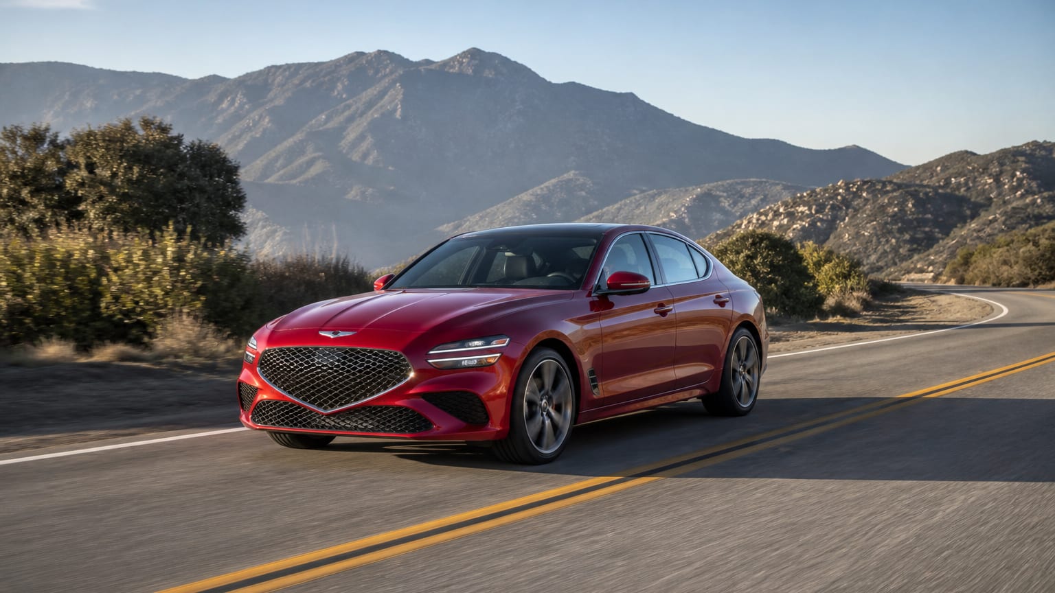 A cleaner later-model Genesis G70 on a quiet road.