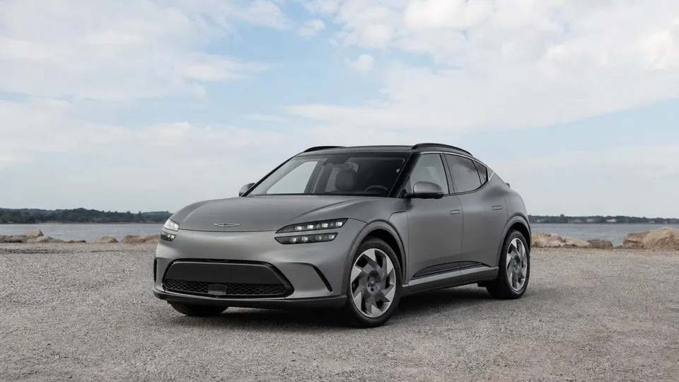 A Genesis GV60 electric crossover, three-quarter front view, parked outdoors.