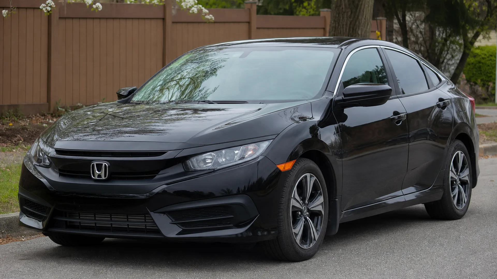 A black Honda Civic sedan parked on a street.