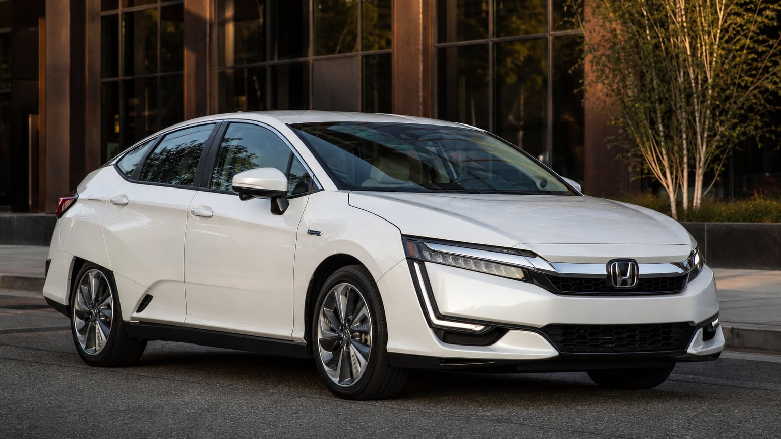 A pearl-white late Honda Clarity Plug-In Hybrid sedan parked on a city street.