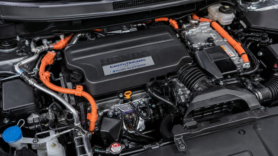 Close-up of a Honda Clarity plug-in hybrid engine bay with orange high-voltage cables.
