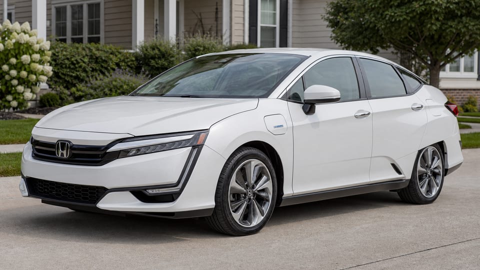 A white Honda Clarity Plug-In Hybrid sedan parked on a suburban driveway.