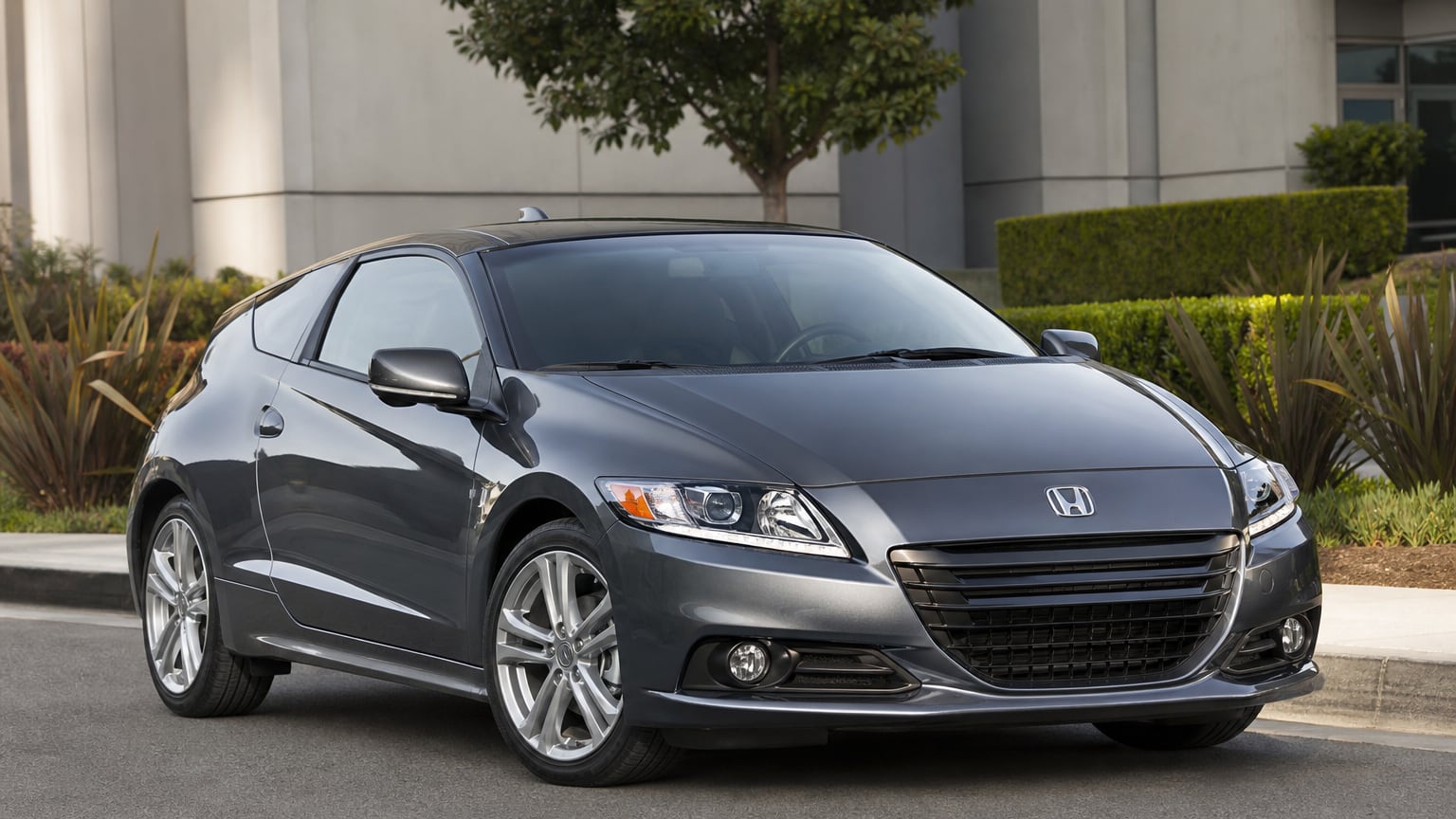 A dark gray late Honda CR-Z hybrid coupe parked on a clean street.