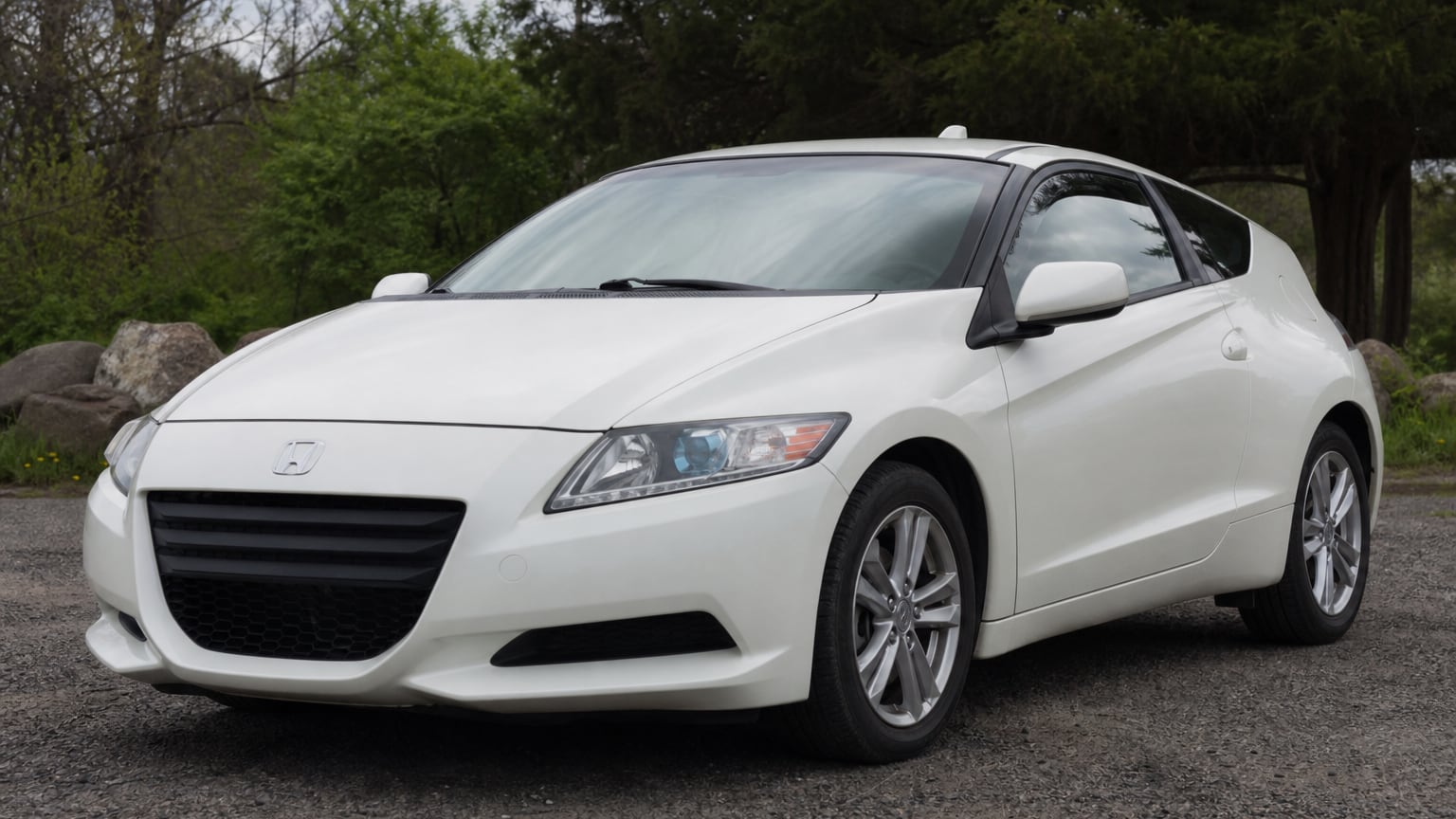 A white early Honda CR-Z hybrid coupe parked outdoors.