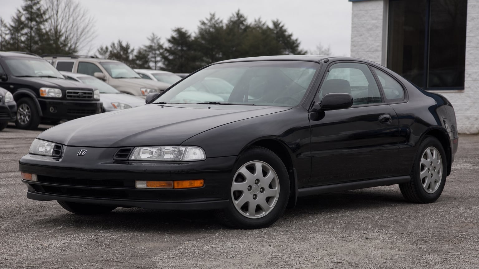 A dark red fourth-generation Honda Prelude coupe parked outdoors.