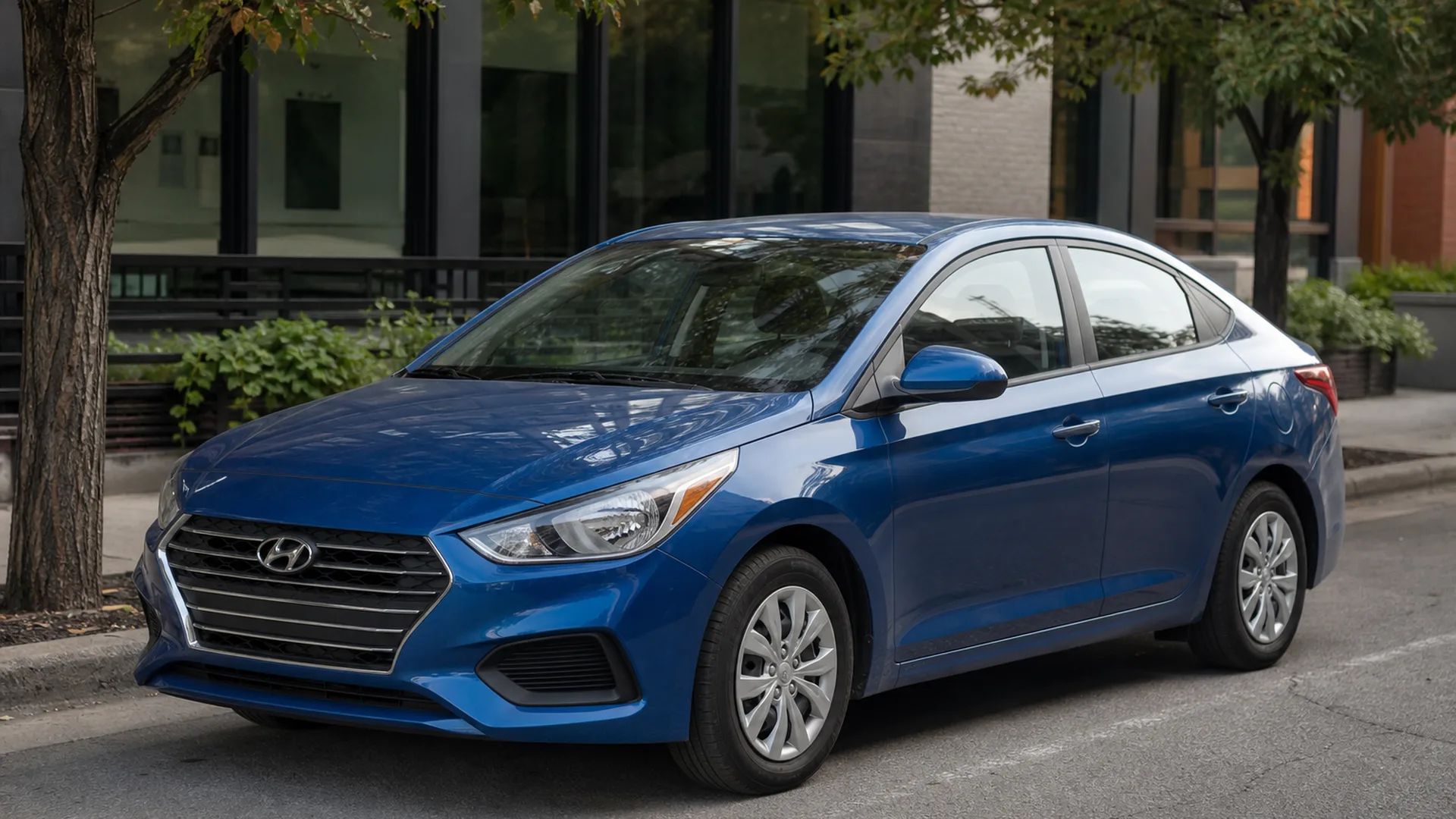 A blue Hyundai Accent sedan parked along a city curb.