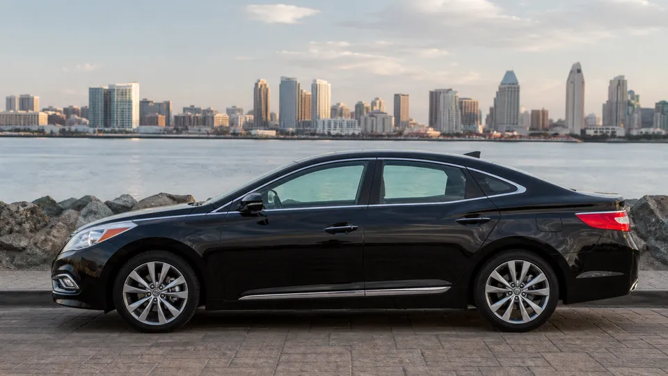 A silver mid-2010s Hyundai Azera sedan parked outside an office building.