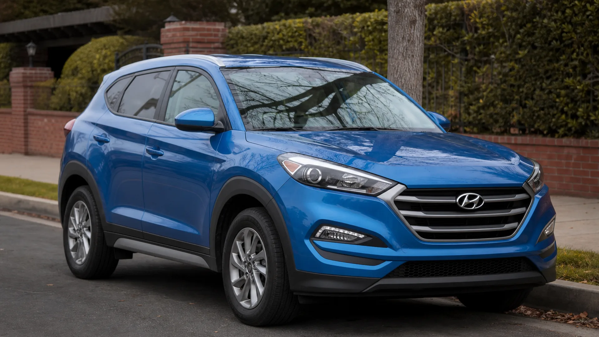 A blue Hyundai Tucson crossover parked on a street.