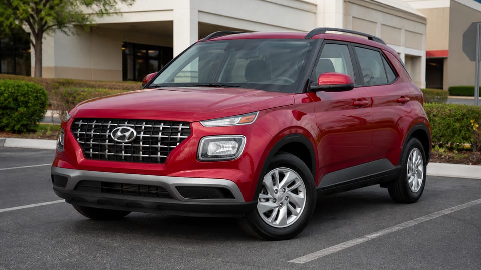 A gray 2020 Hyundai Venue SE parked in a shopping center lot.