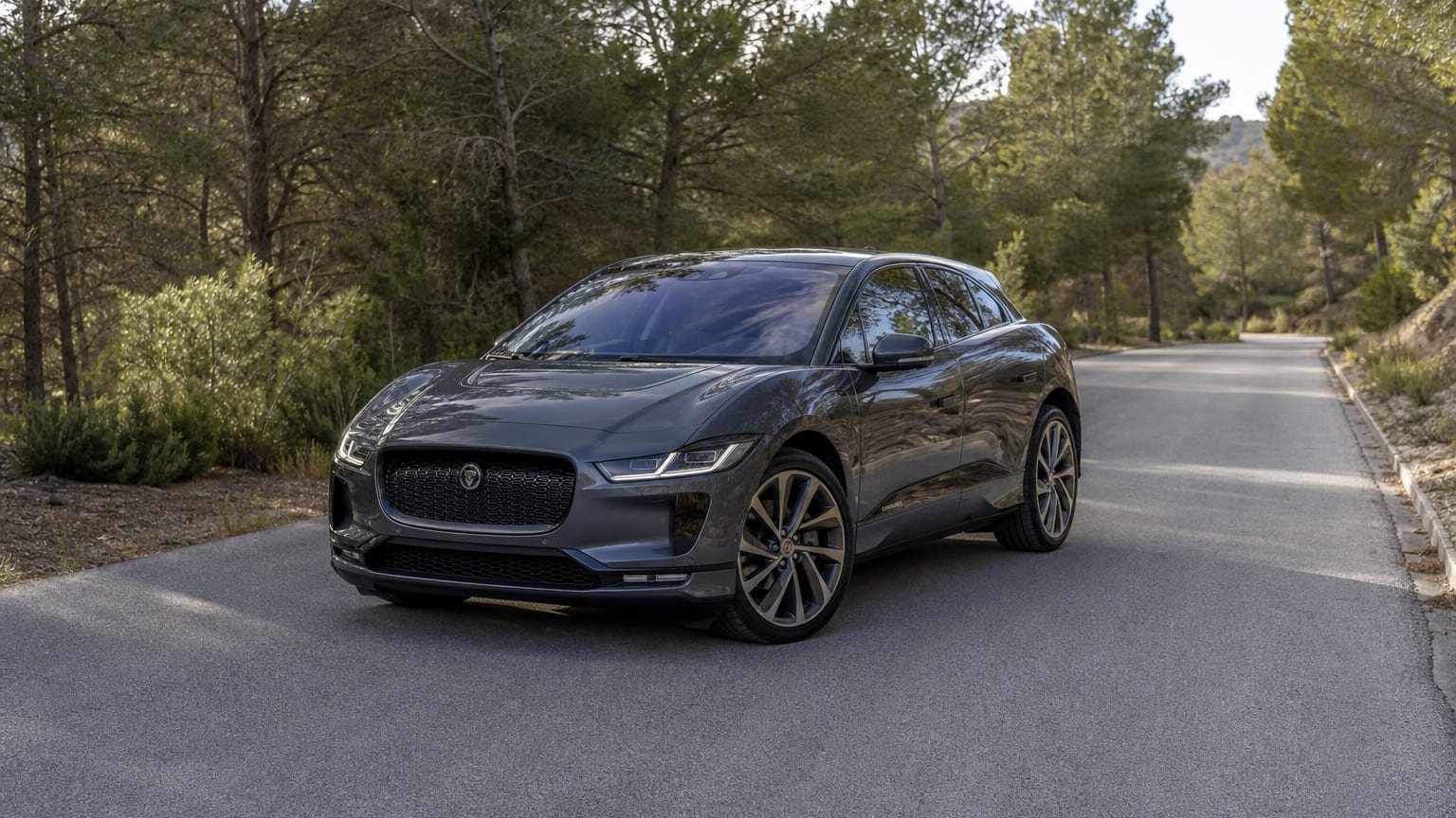 A cleaner later-model Jaguar I-Pace on a quiet road.