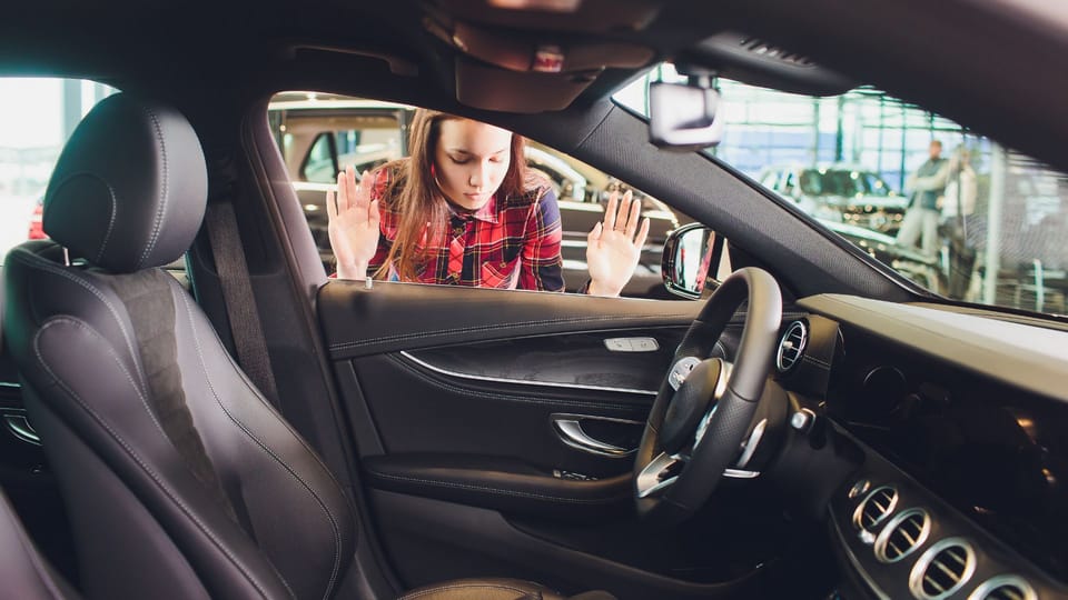 a woman sitting in the driver's seat of a car.|a man is opening a door with a key.