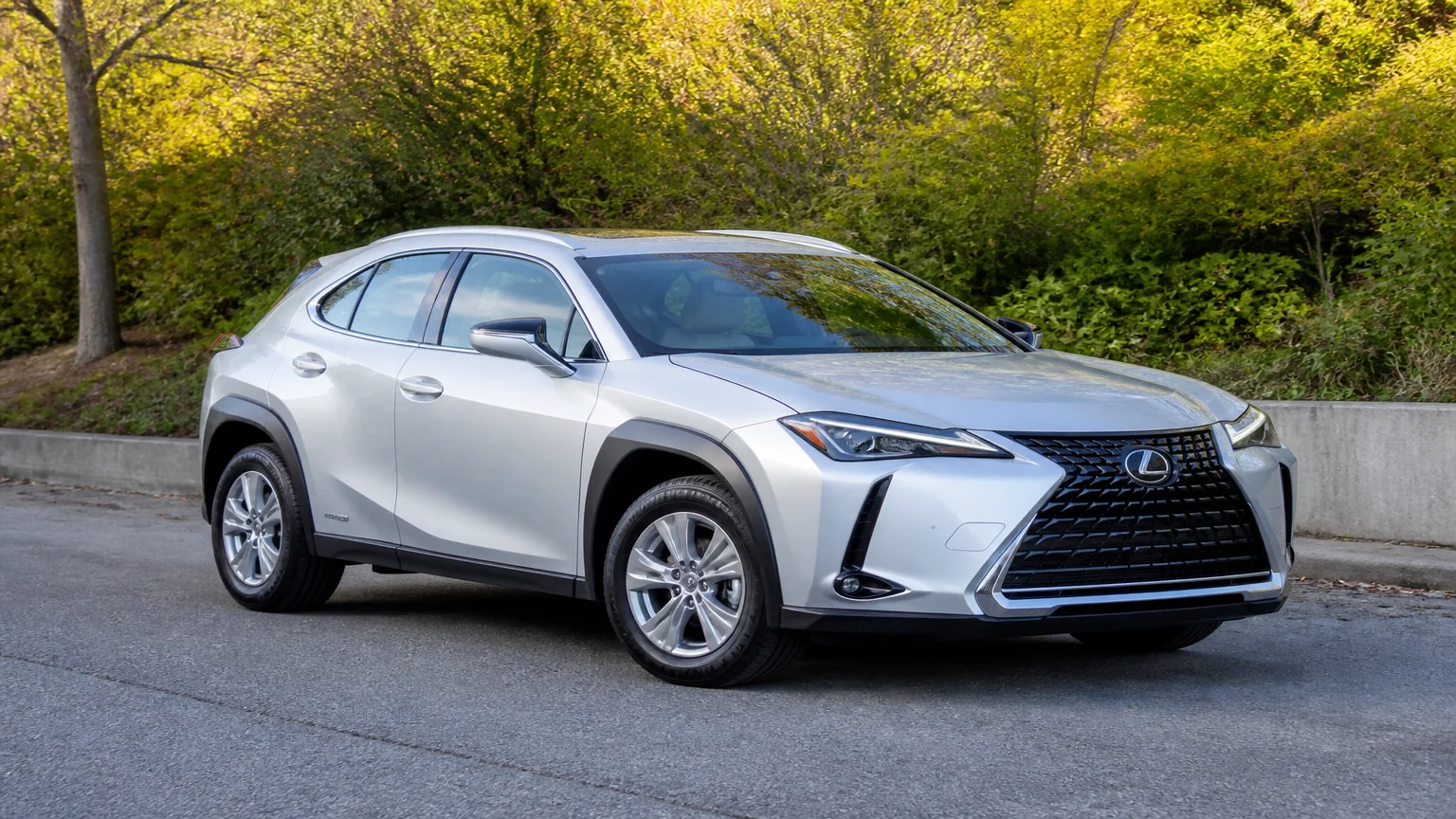 A Lexus UX compact luxury crossover, three-quarter front view, parked on a quiet street.