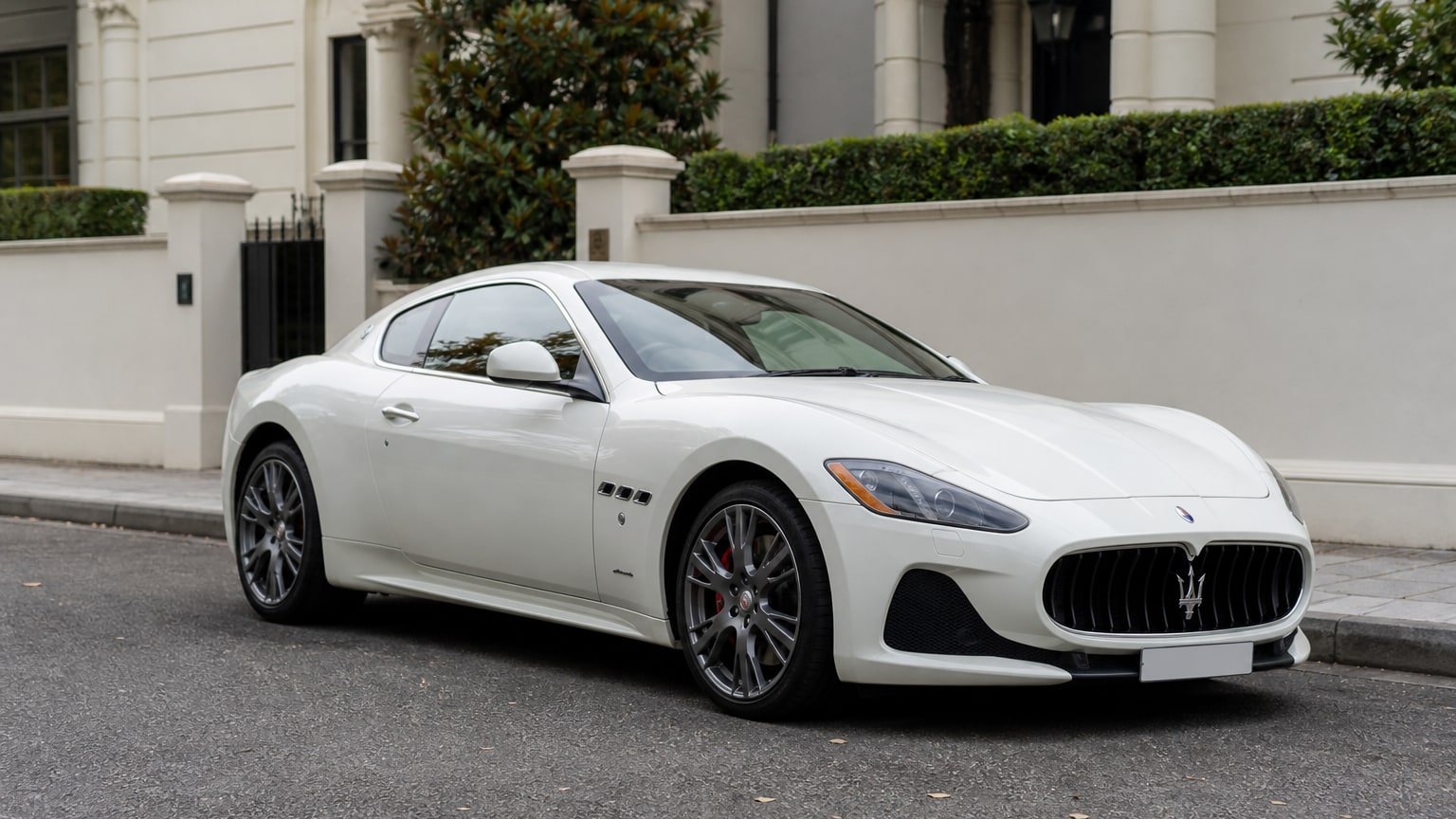 A Maserati GranTurismo parked outdoors, three-quarter front view.