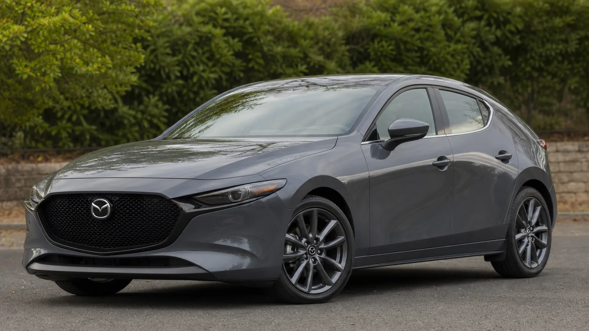 A grey Mazda 3 hatchback parked outdoors.