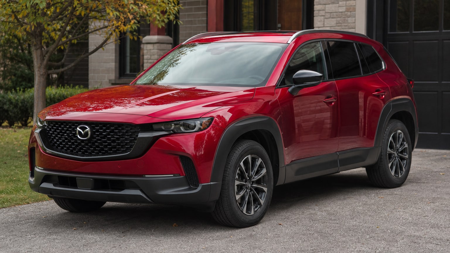 A gray 2023 Mazda CX-50 parked in a suburban driveway.