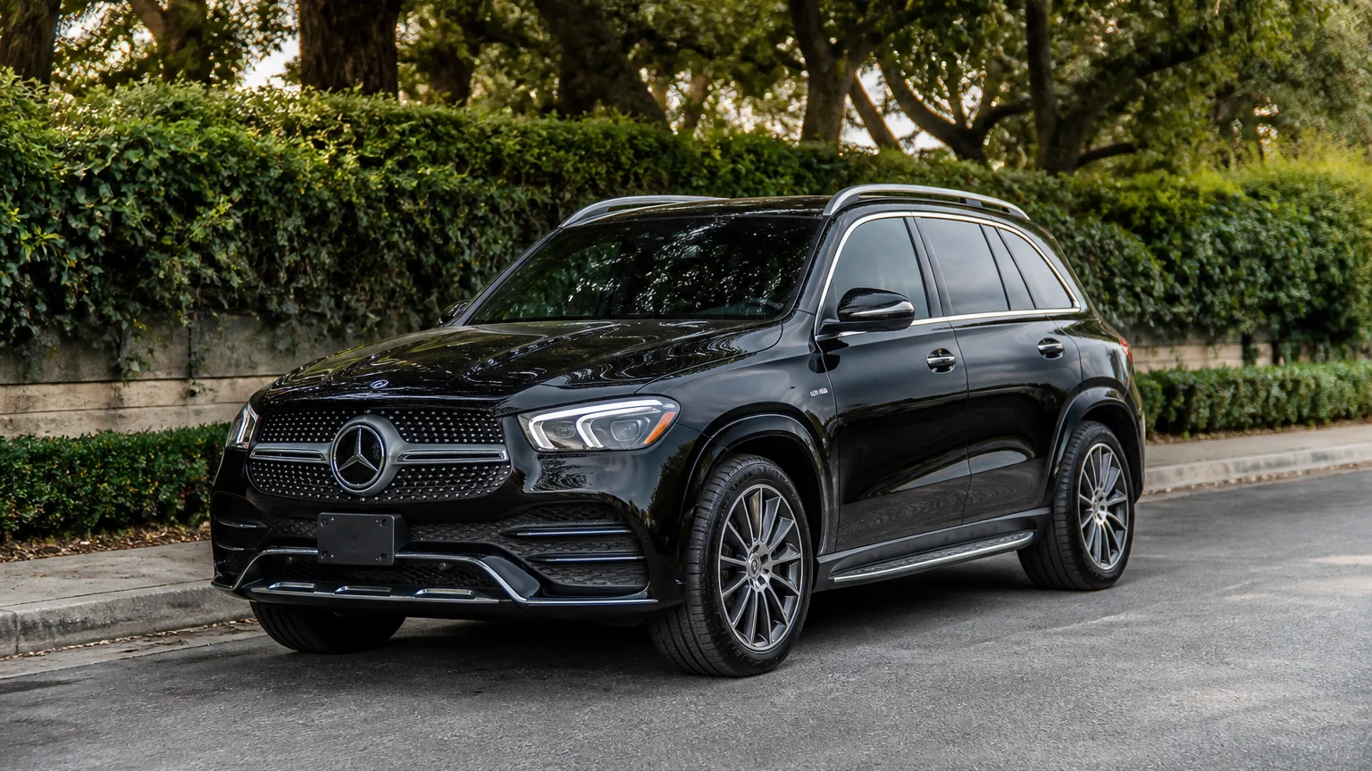 A Mercedes-Benz GLE midsize luxury SUV, three-quarter front view, parked on a quiet street.